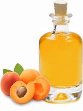 Bottle of organic apricot oil with apricots and blossoms around it