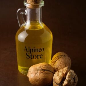 A bottle of golden walnut oil with a small puddle and walnuts nearby on a wooden surface.
